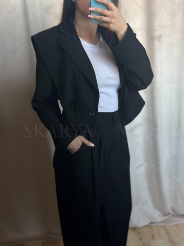 Czarny elegancki komplet. Krótka marynarka z podkreśloną linią ramion zapinana na guzik. Spodnie na gumce z szeroką nogawką typu wide leg, szlufki na pasek, kieszenie, lekki zwiewny materiał. Idealny na wyjątkowe okazje jak i na co dzień.