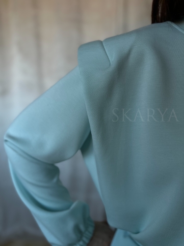 Niebieski komplet dresowy damski. Krótka bluza regulowana ściągaczem, z podkreśloną linią ramion. Spodnie typu jogger ze ściągaczem na nogawkach. Nietypowy dres, który łączy w sobie wygodę i modowy charakter. Wykonany z miękkiego w dotyku materiału.