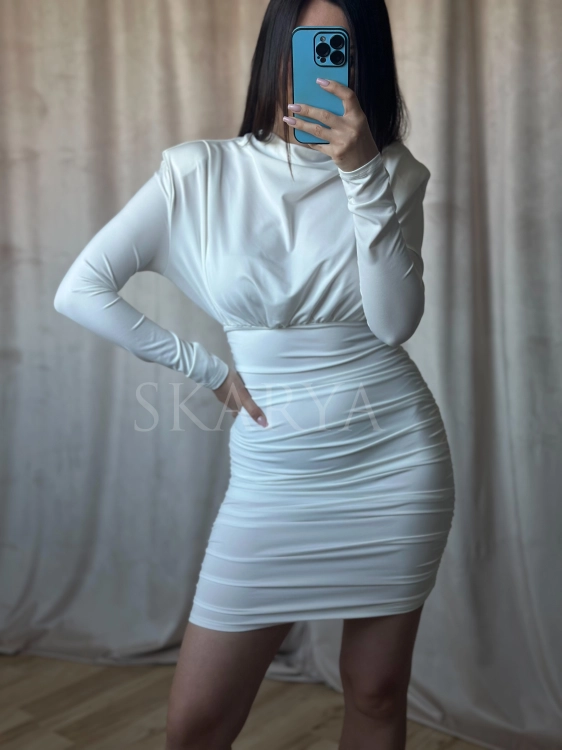 Elegancka biała sukienka mini dopasowana do sylwetki, wykonana z elastycznego materiału, który doskonale układa się na ciele. Fason typu bodycon subtelnie modeluje figurę i podkreśla kształty, zapewniając jednocześnie komfort noszenia i swobodę ruchów
