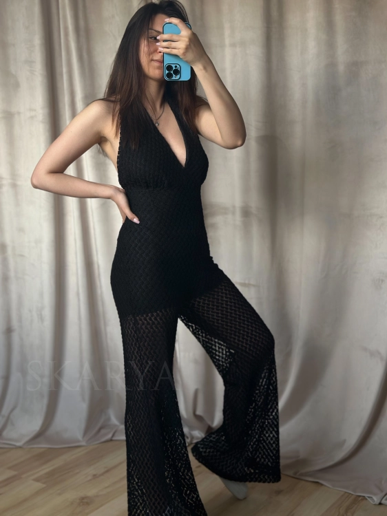 Czarny ażurowy kombinezon marki LOLA Fashion. Szeroka nogawka typu wide leg, wiązany na szyi, dzięki czemu można regulować głębokość dekoltu. Zapinany na zamek. Idealny na wakacje. Świetnie się sprawdzi w letnie dni. Pięknie podkreśla sylwetkę.