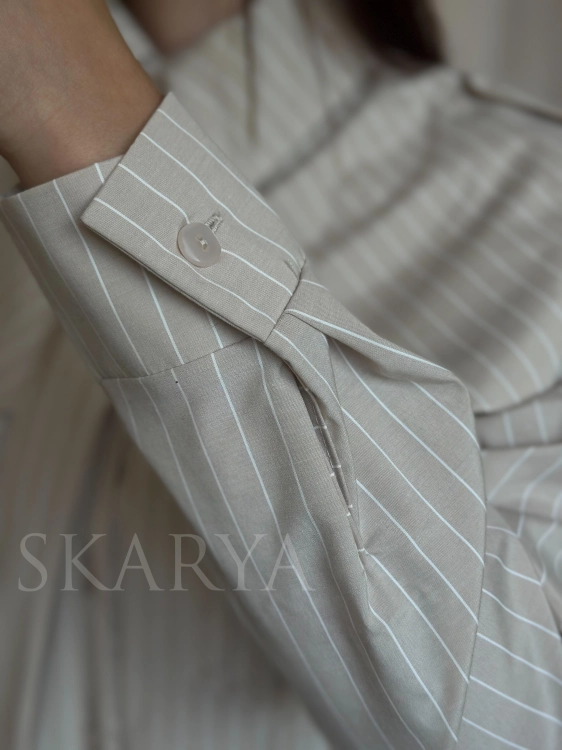Beżowa koszula w białe paski MILO La Balancia w butiku online SKARYA to wybór idealny dla kobiet, które lubią niebanalną elegancję, klasykę w ciekawszej formie, ponadczasowe ubrania i zabawę modą. Ta koszula to idealna baza do wielu ciekawych outfitów